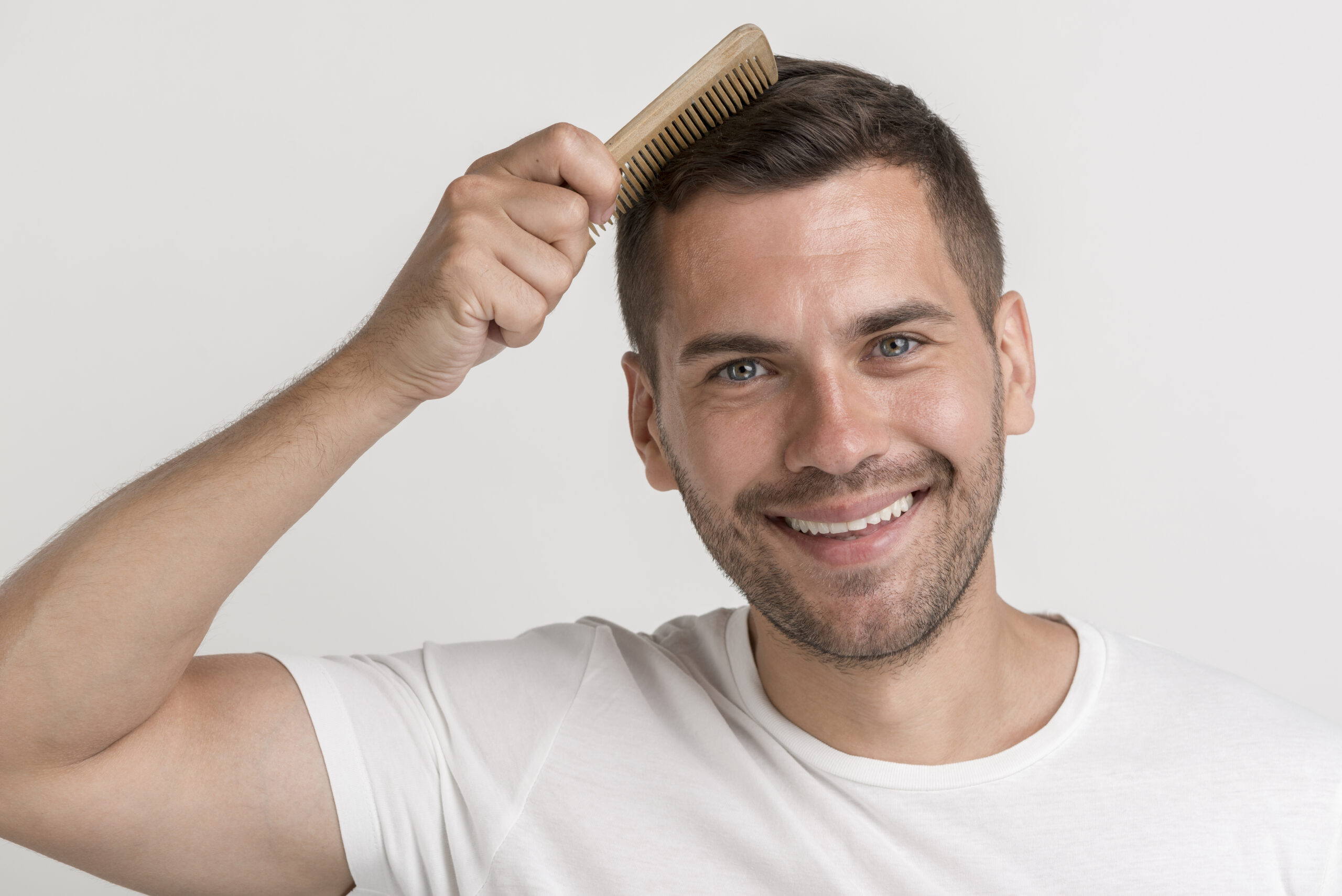 portrait-smiling-young-man-white-t-shirt-comb-his-hair